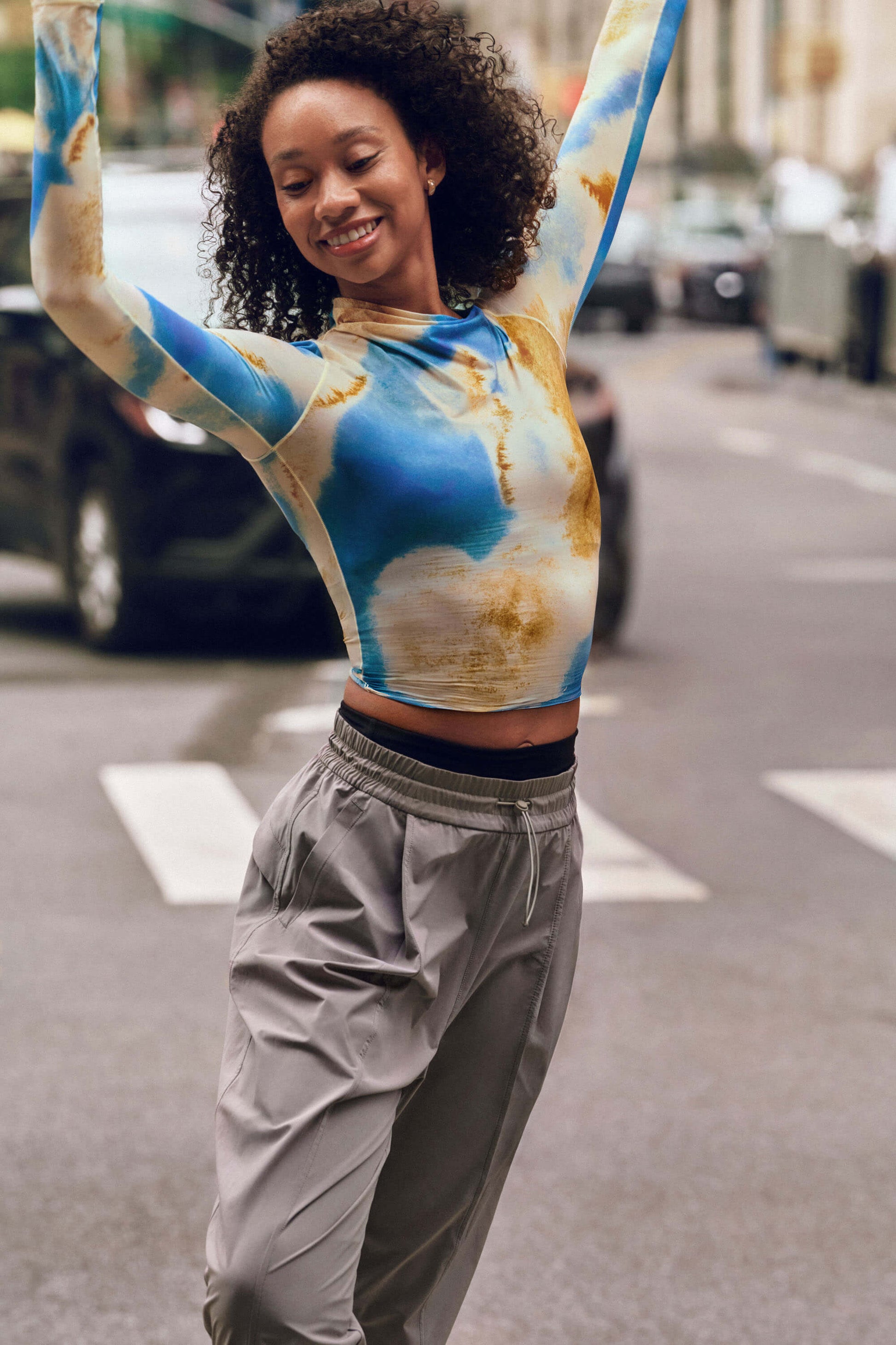 Dancer wearing blue and gold long sleeve top and gray pants