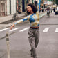 Dancer wearing blue and gold long sleeve top and gray pants