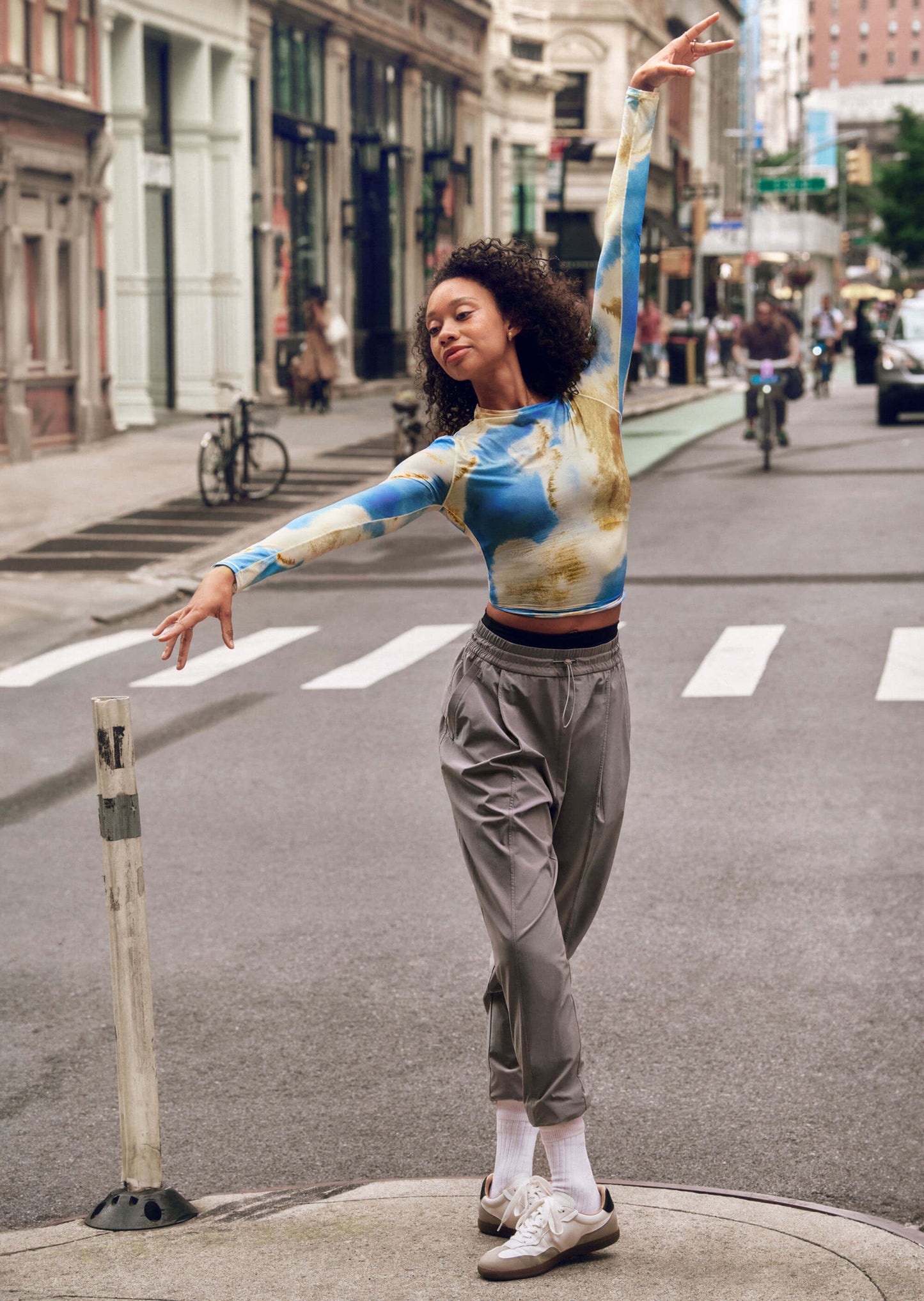 Dancer wearing blue and gold long sleeve top and gray pants