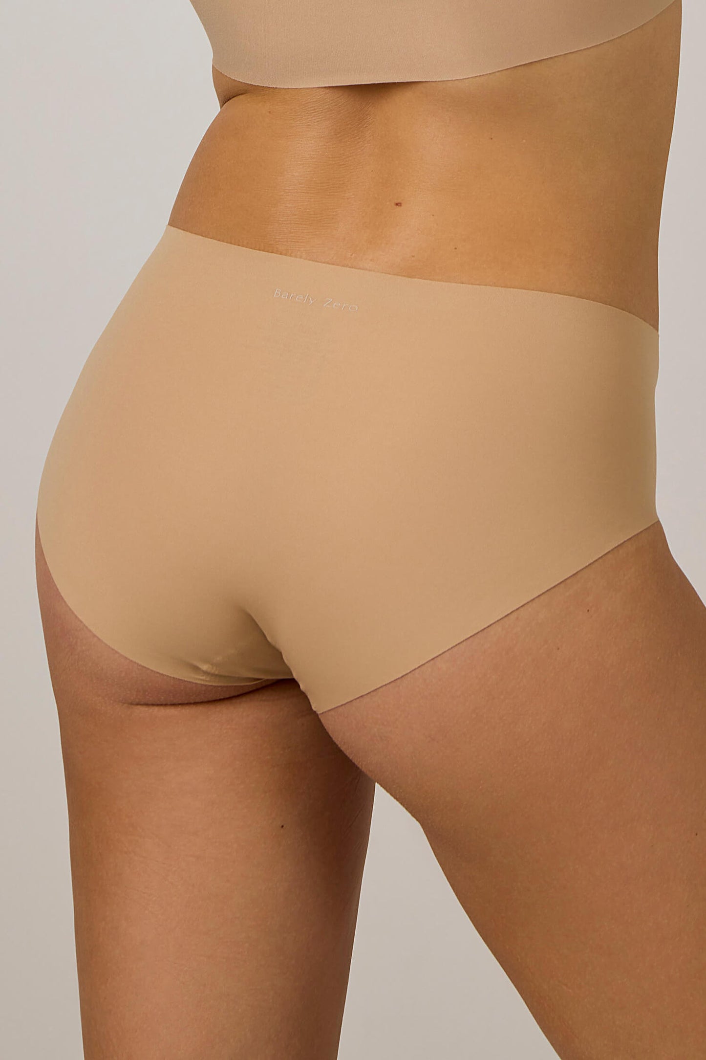 back of a woman in tan underwear