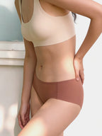 Model wearing beige bra and brown underwear against a light background. Cinnamon Taste color.