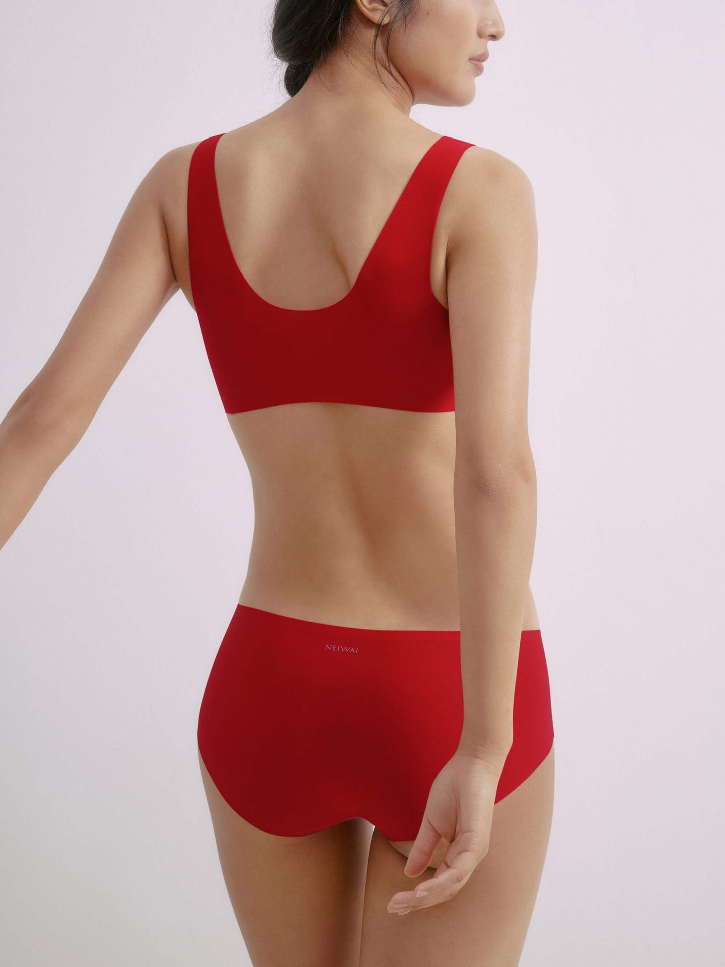 Back side of woman wearing matching red bra and briefs