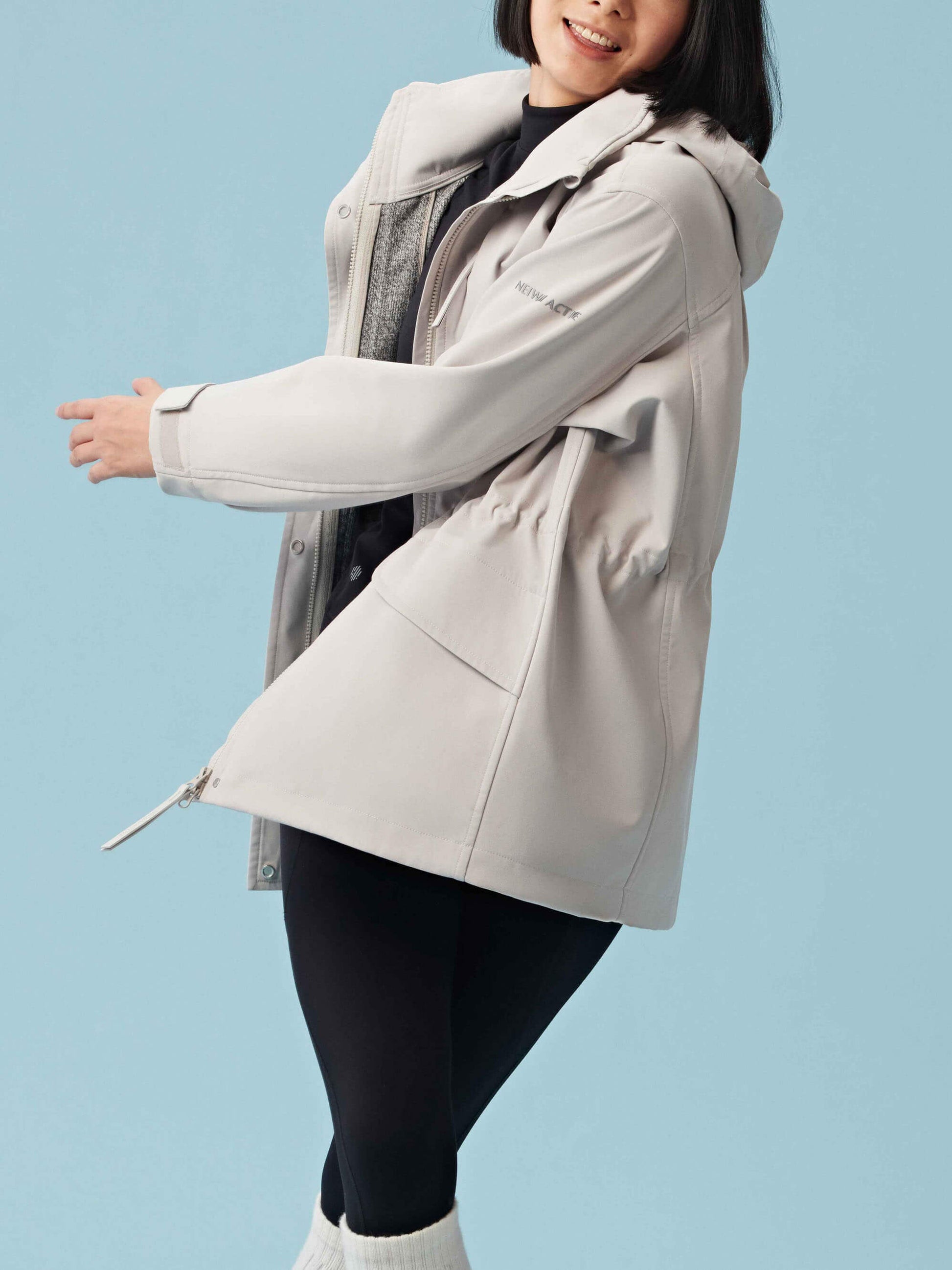 Woman wearing zipped up gray hooded coat