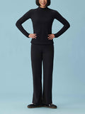 Front view of woman wearing black woven fleece pants