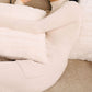 Woman laying down and wearing white wool seamless turtleneck