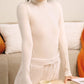 Front view of woman wearing white wool seamless turtleneck