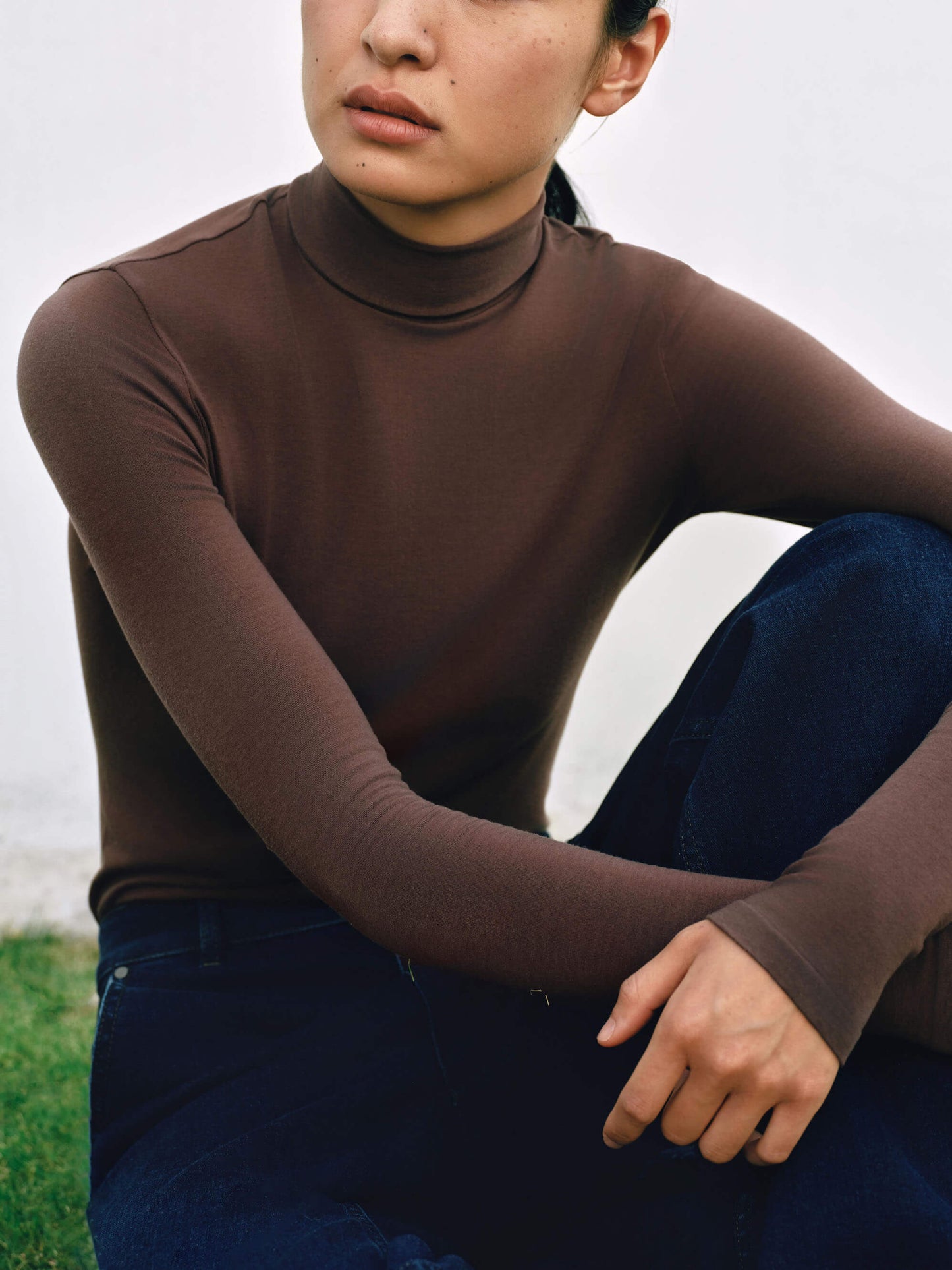 Front view of woman wearing brown wool seamless turtleneck