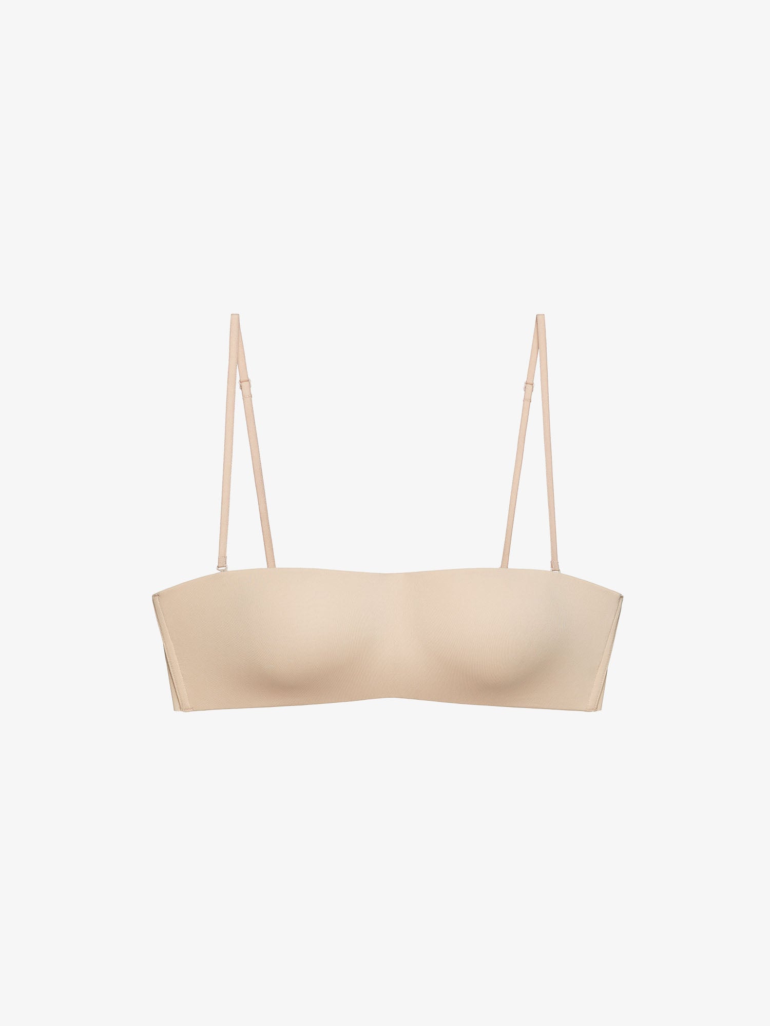 Flatlay of beige strapless bra on a white background.