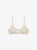 Flat lay of eggshell white bra with keyhole detailing
