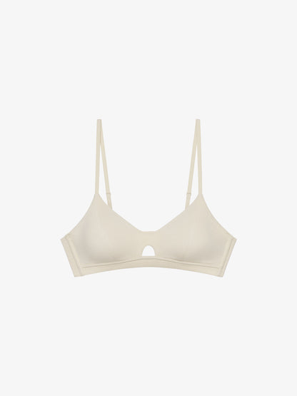 Flat lay of eggshell white bra with keyhole detailing