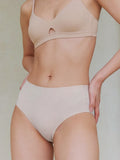 Model wearing a beige bra and underwear set against a neutral background. Fluffy Peach color.