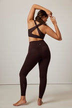back of woman in brown sports bra and leggings