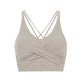 flat lay picture of a light grey color v-neck sports bra with ruched details and crossing back straps