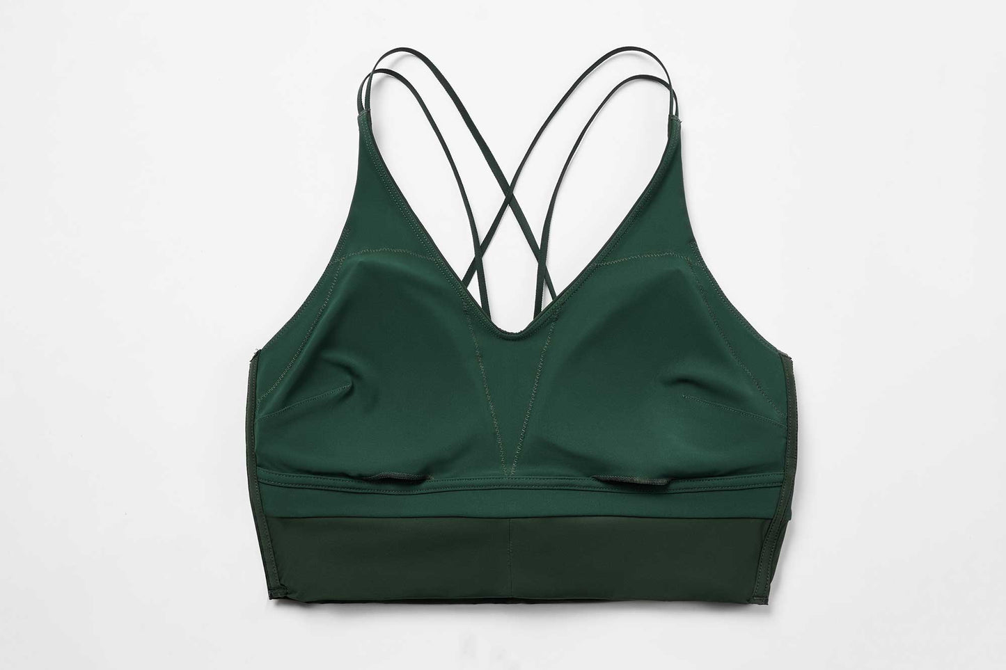 the inside look of the green sports bra, showing the pockets for the removable pads