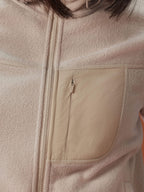 close up of the beige fleece jacket showcasing the pocket on the chest.