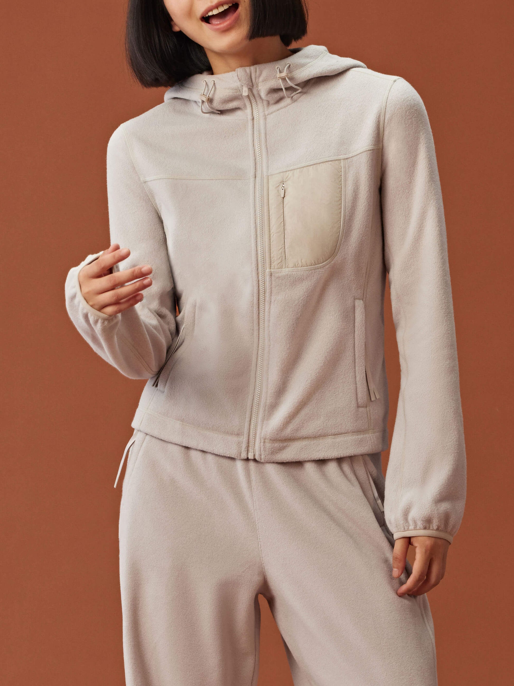 woman in beige zipped hooded fleece jacket and matching pants