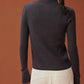 back of woman in dark purple zipped ribbed cardigan