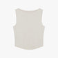 Flat lay of white sleeveless top with a ribbed lower section, displayed flat against a white background.