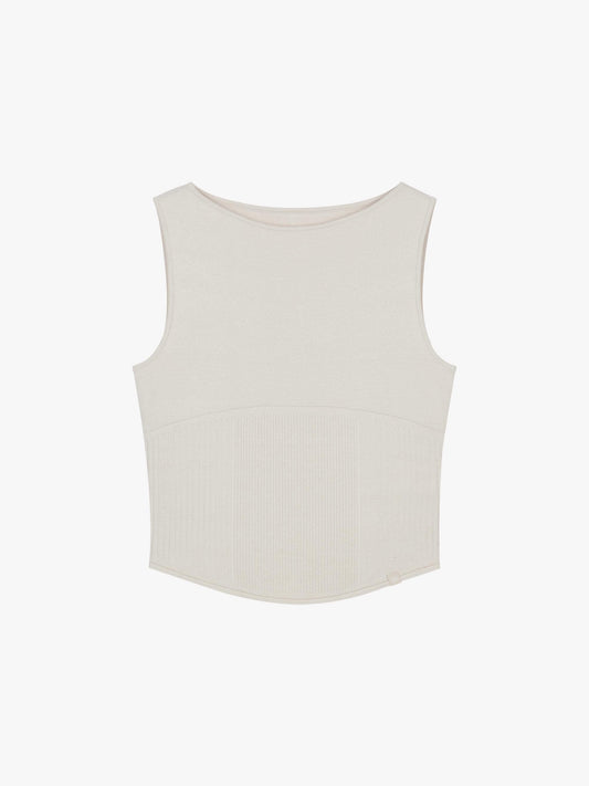 Flat lay of white sleeveless top with a ribbed lower section, displayed flat against a white background.