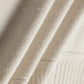 Close-up of cream-colored fabric with a soft, ribbed texture, showing the material’s weave and softness. 