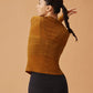 back of woman in golden brown wool top