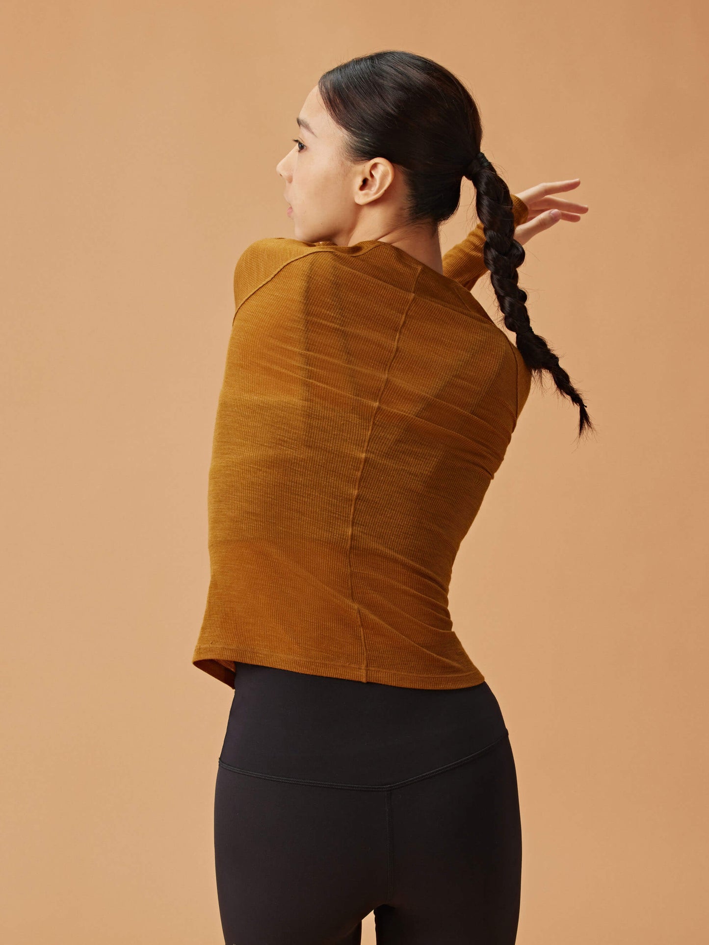 back of woman in golden brown wool top