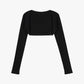 Flat lay of a black ballet wool ribbed shrug displayed against a white background. 