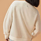 Back view of woman wearing white sweatshirt and black shorts