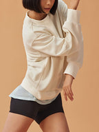 Woman wearing white sweatshirt and black shorts