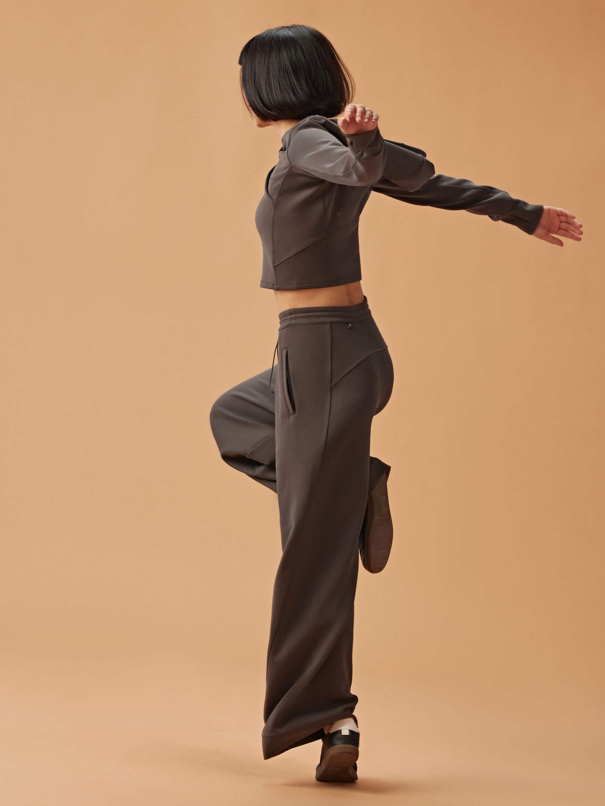 side of woman in dark gray hoodie and matching wide leg pants