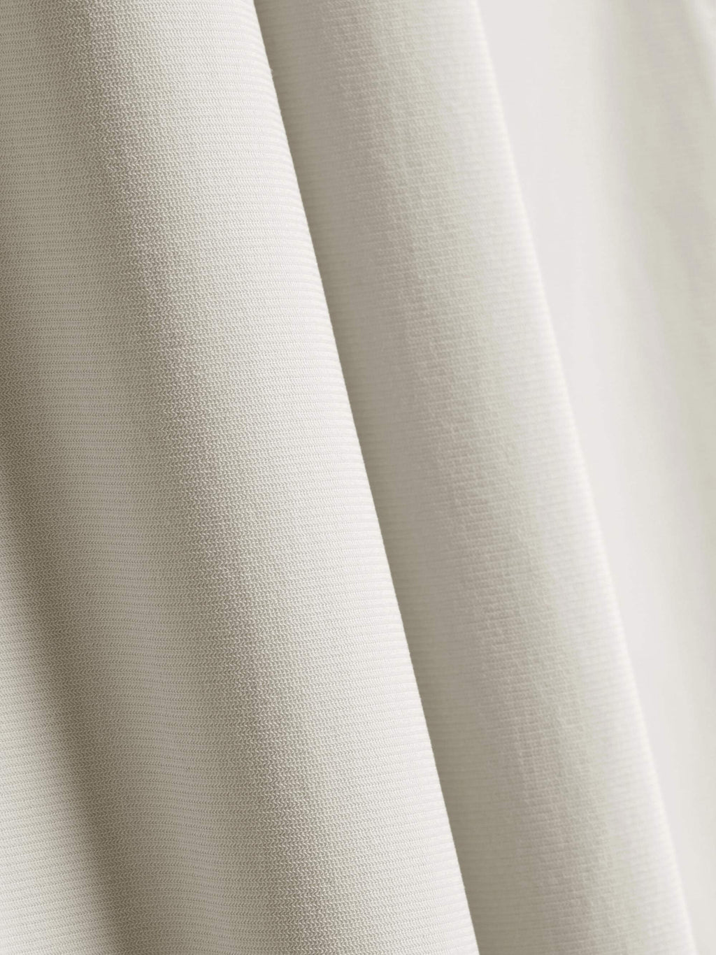 Close-up of the fabric used for white straight-leg pants, showcasing its fine texture and quality. 