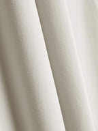 Close-up of the fabric used for white straight-leg pants, showcasing its fine texture and quality. 