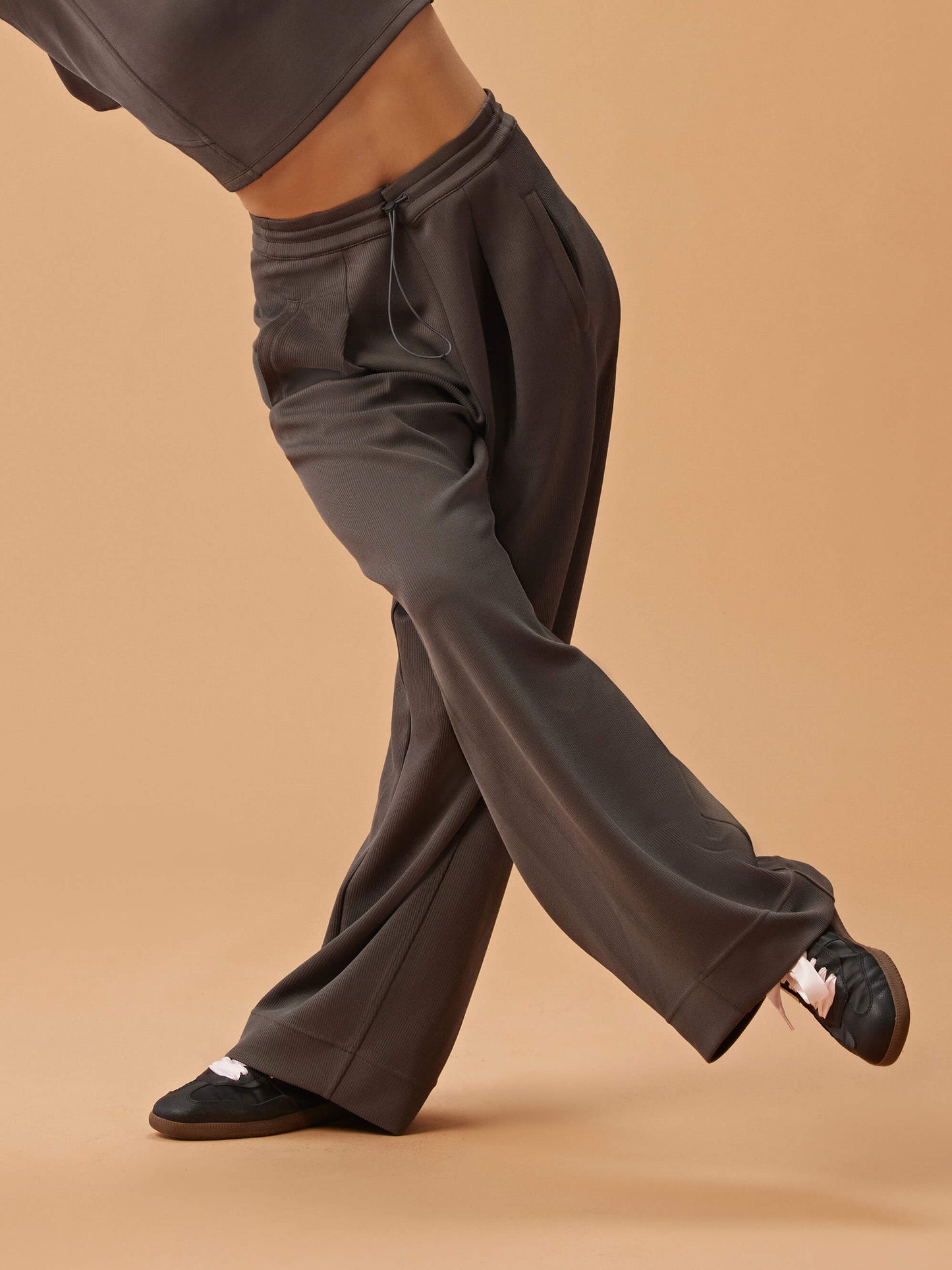 woman in dark gray wide leg pants