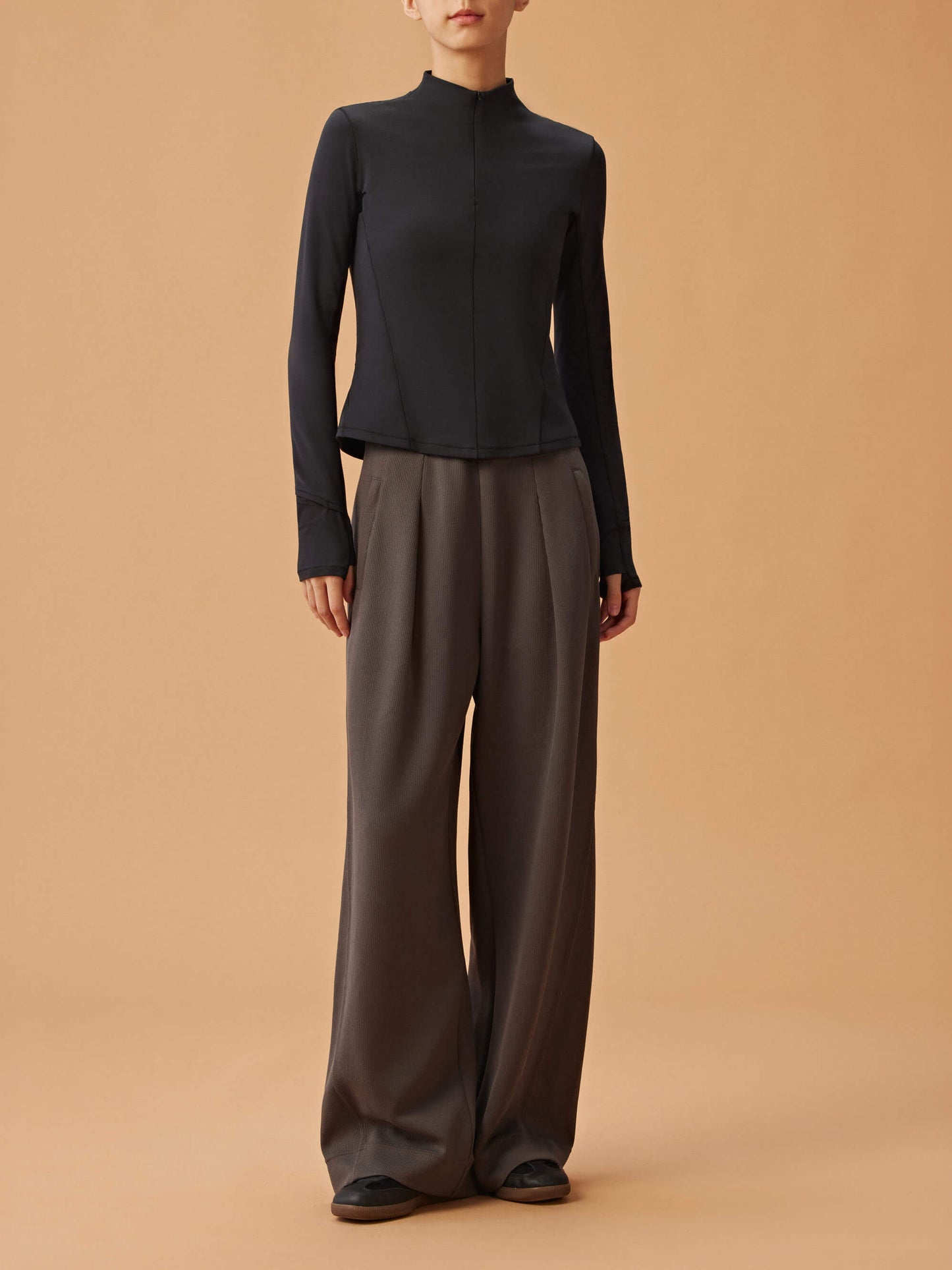 woman in black long sleeve top and dark gray wide leg pants