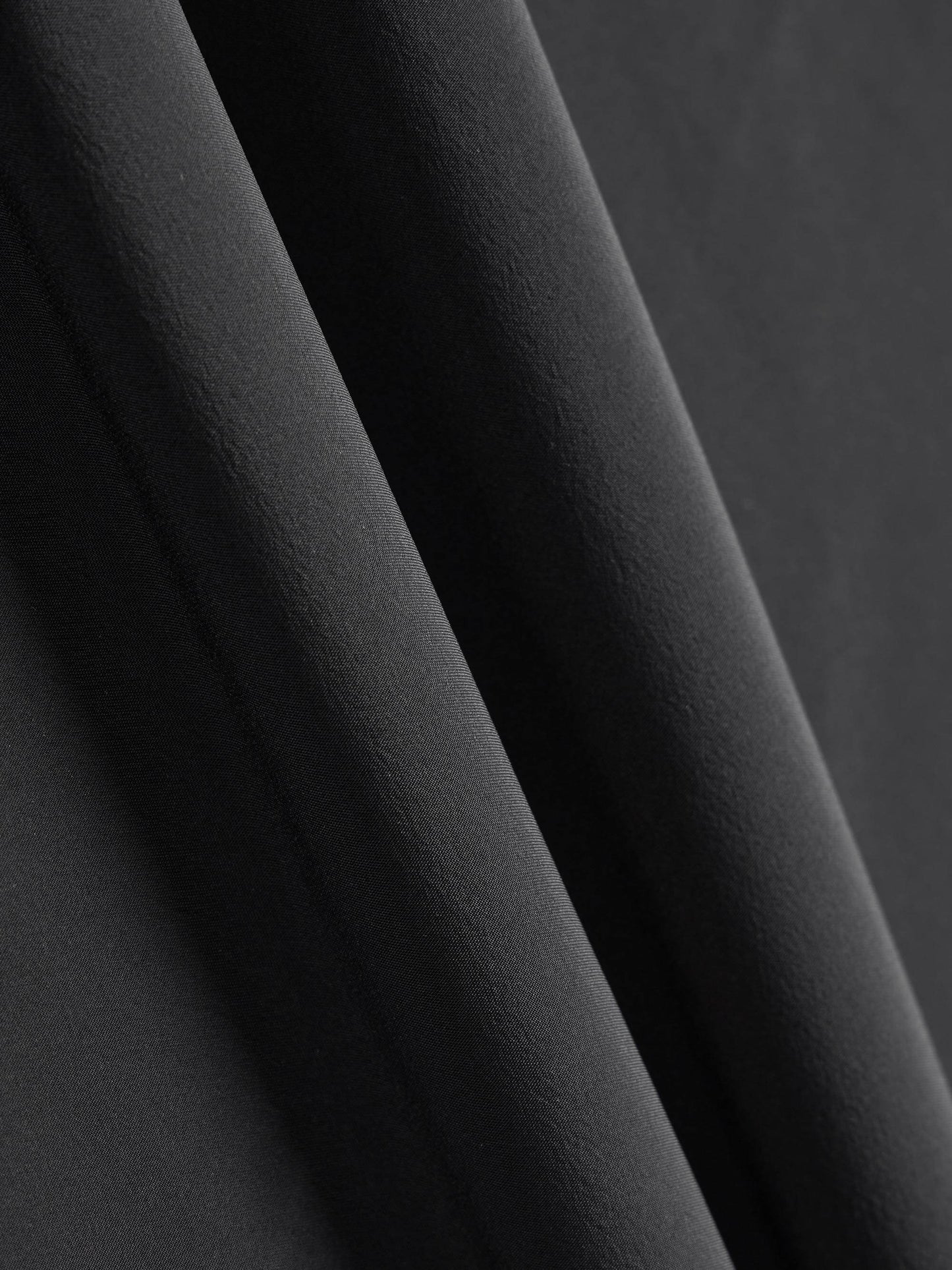 Close-up of black fabric with a smooth, slightly textured surface.