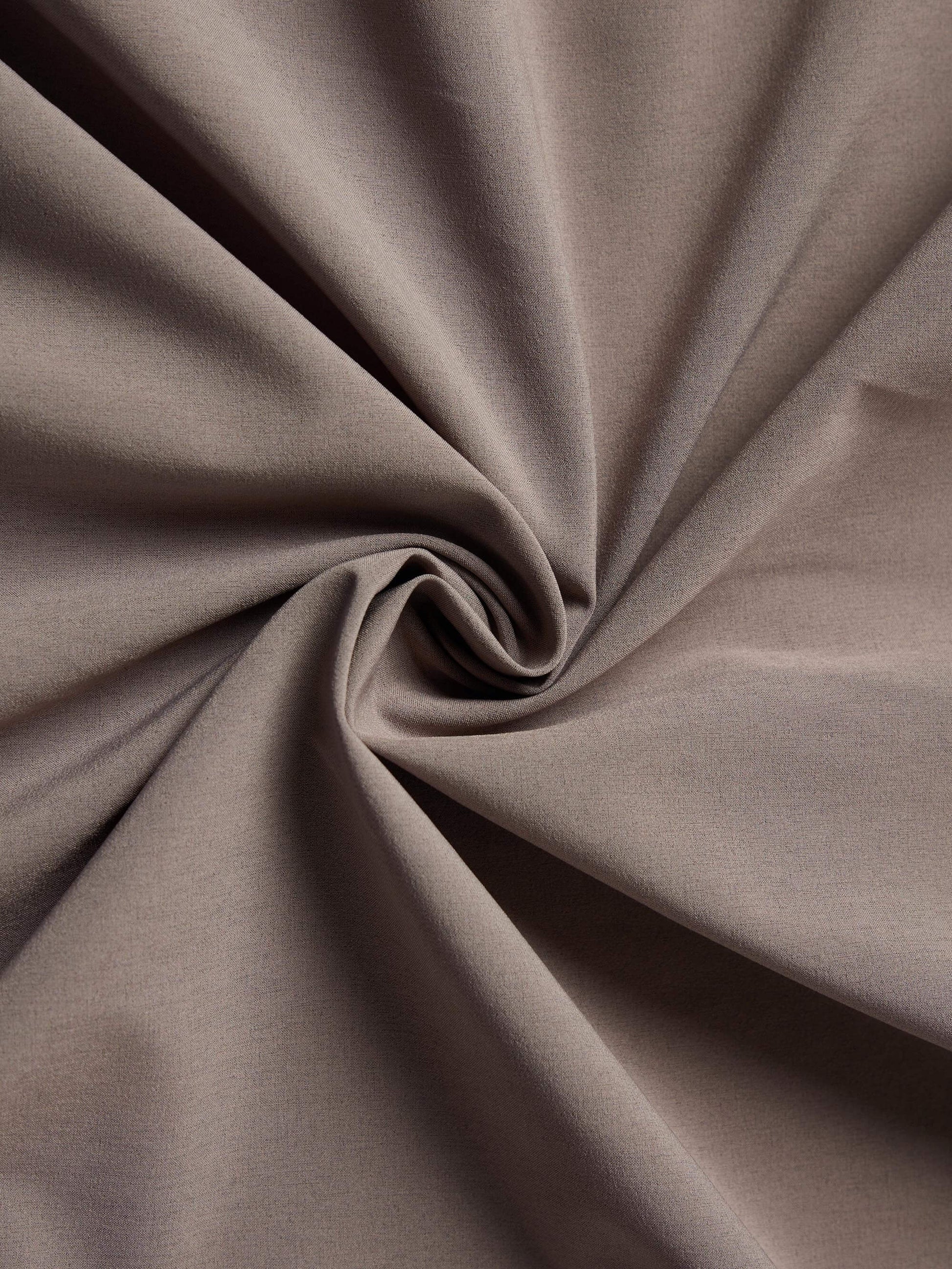 Close-up image of taupe fabric with a soft and smooth texture, twisted to showcase its flexibility and drape.