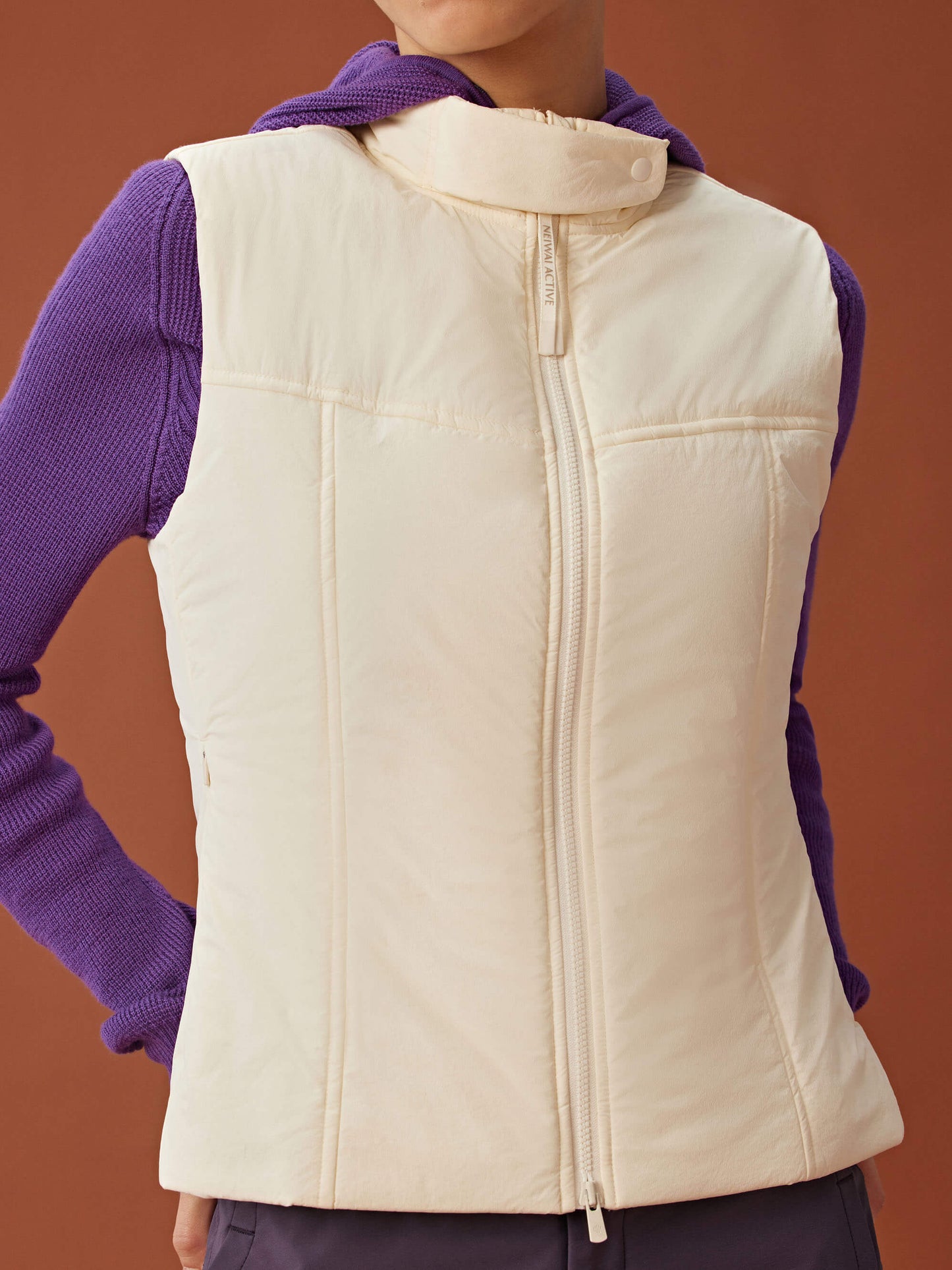 woman in purple knitted hoodie and white vest.