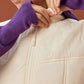 close up of woman in white vest clipping the button on the vest collar