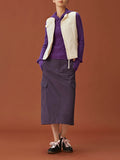 woman in purple hoodie, white vest and purple midi skirt.