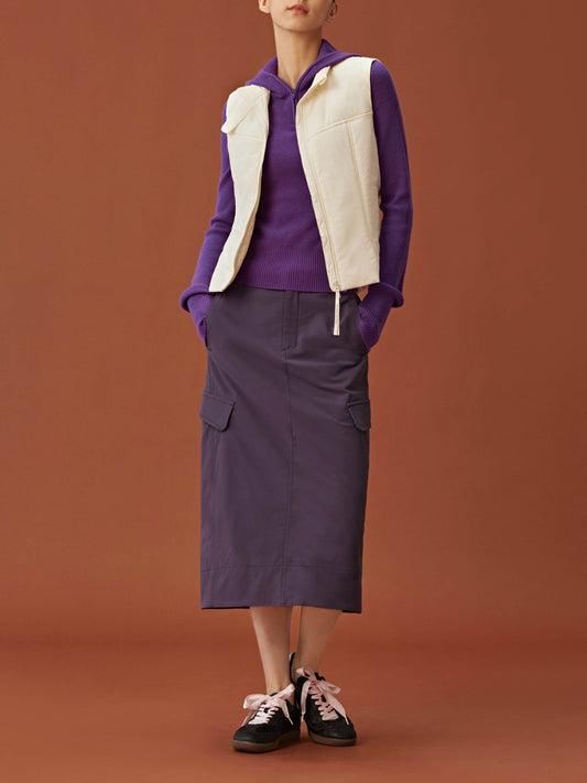 woman in purple hoodie, white vest and purple midi skirt.