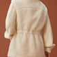 back of woman in white fleece coat with gathered waist and knitted sleeves