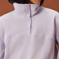 close up of woman in light purple fleece sweatshirt showcasing the buttons on collar