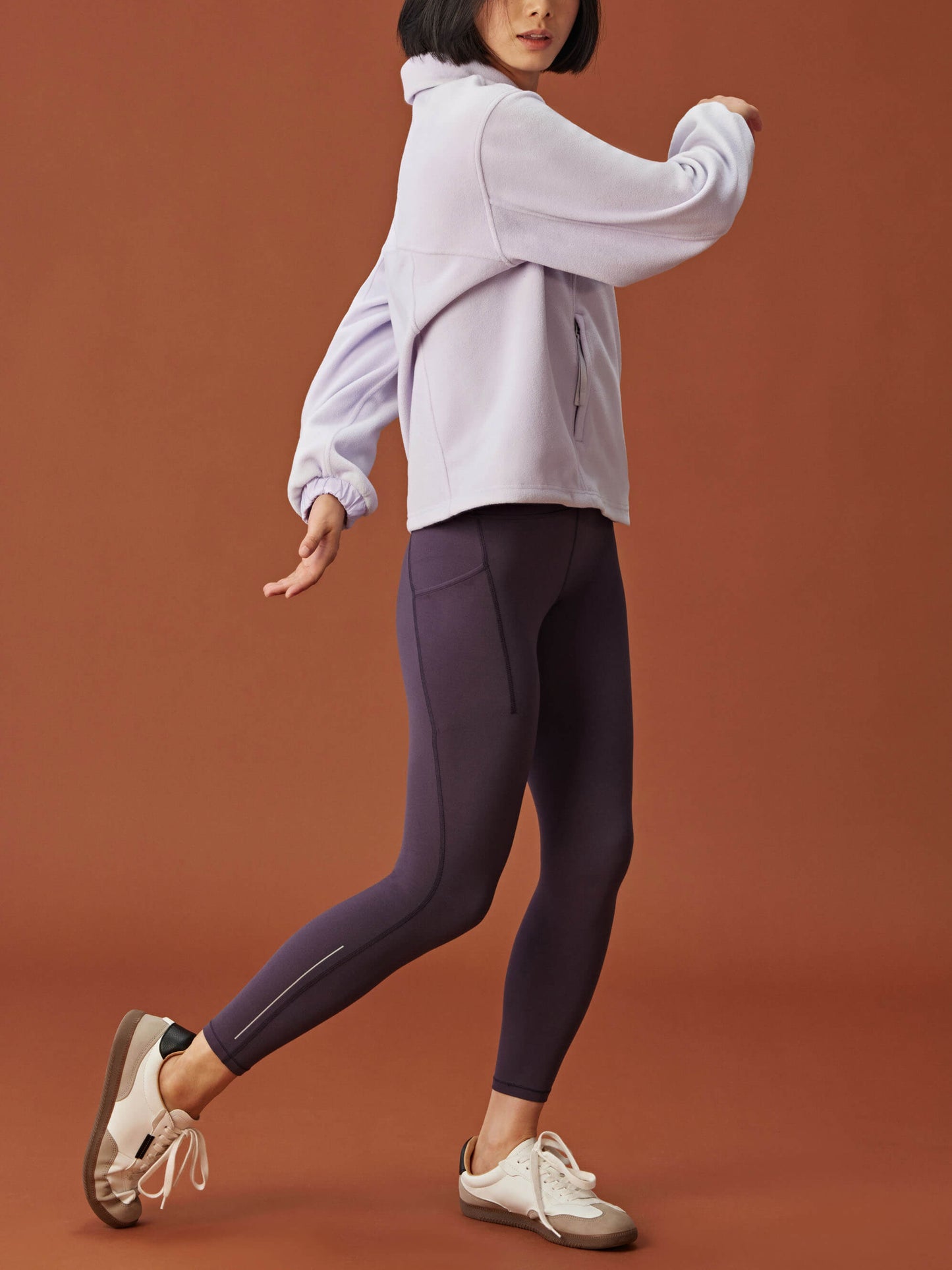 woman in light purple fleece sweatshirt and dark purple leggings