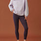 woman in light purple fleece sweatshirt and dark purple leggings