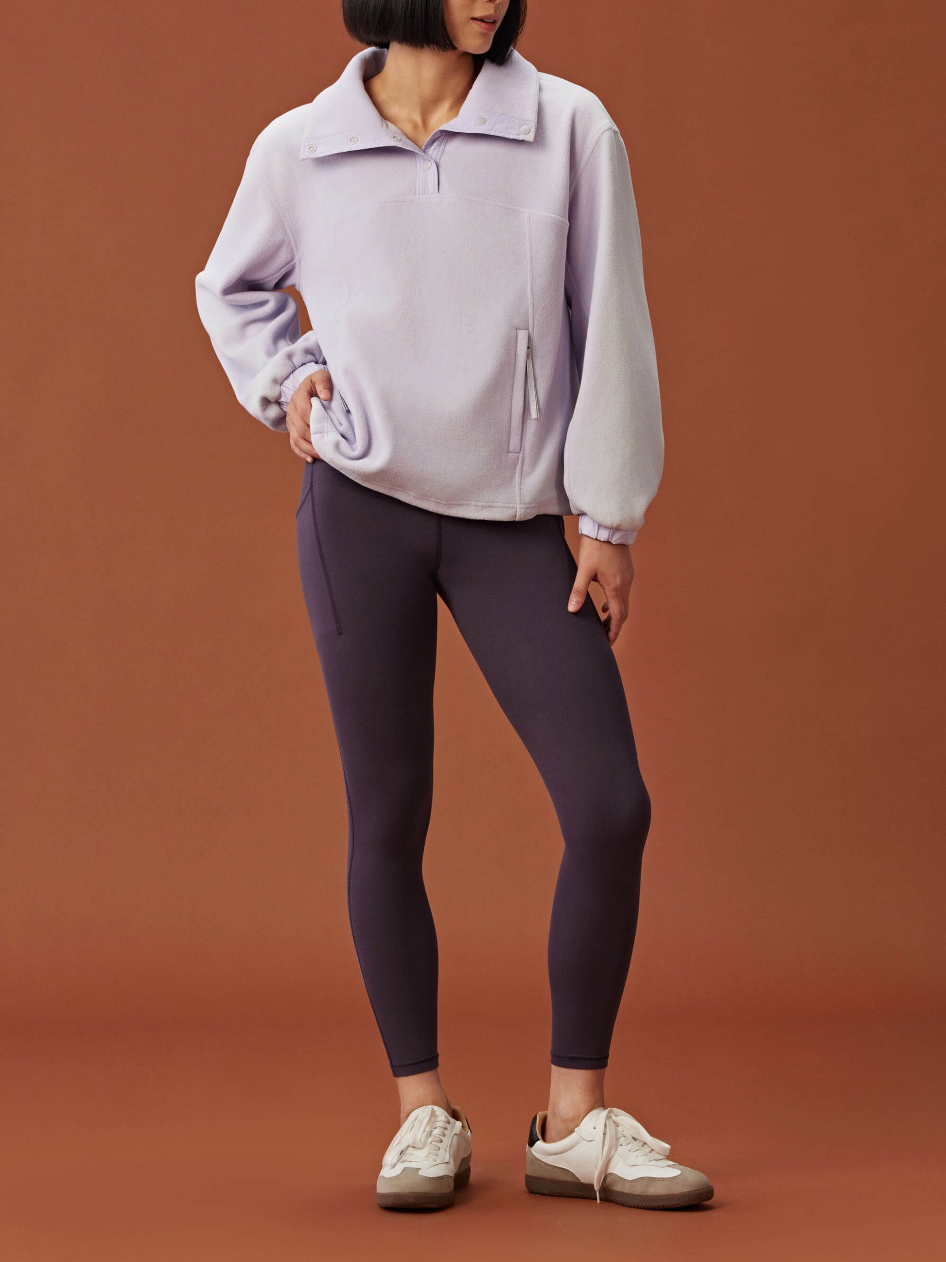 woman in light purple fleece sweatshirt and dark purple leggings