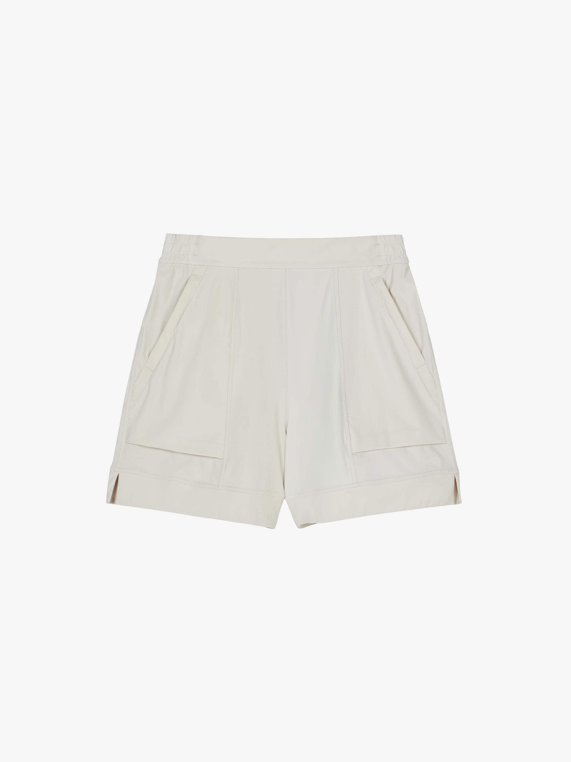 Flat lay of a pair of light gray mid-waist shorts displayed on a plain background. The shorts feature an elastic waistband, side pockets, and a clean, minimalistic design.