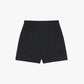 Flat lay of a pair of light black mid-waist shorts displayed on a plain background. The shorts feature an elastic waistband, side pockets, and a clean, minimalistic design.