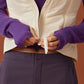 close up of woman in purple hoodie, white vest and dark purple midi skirt.