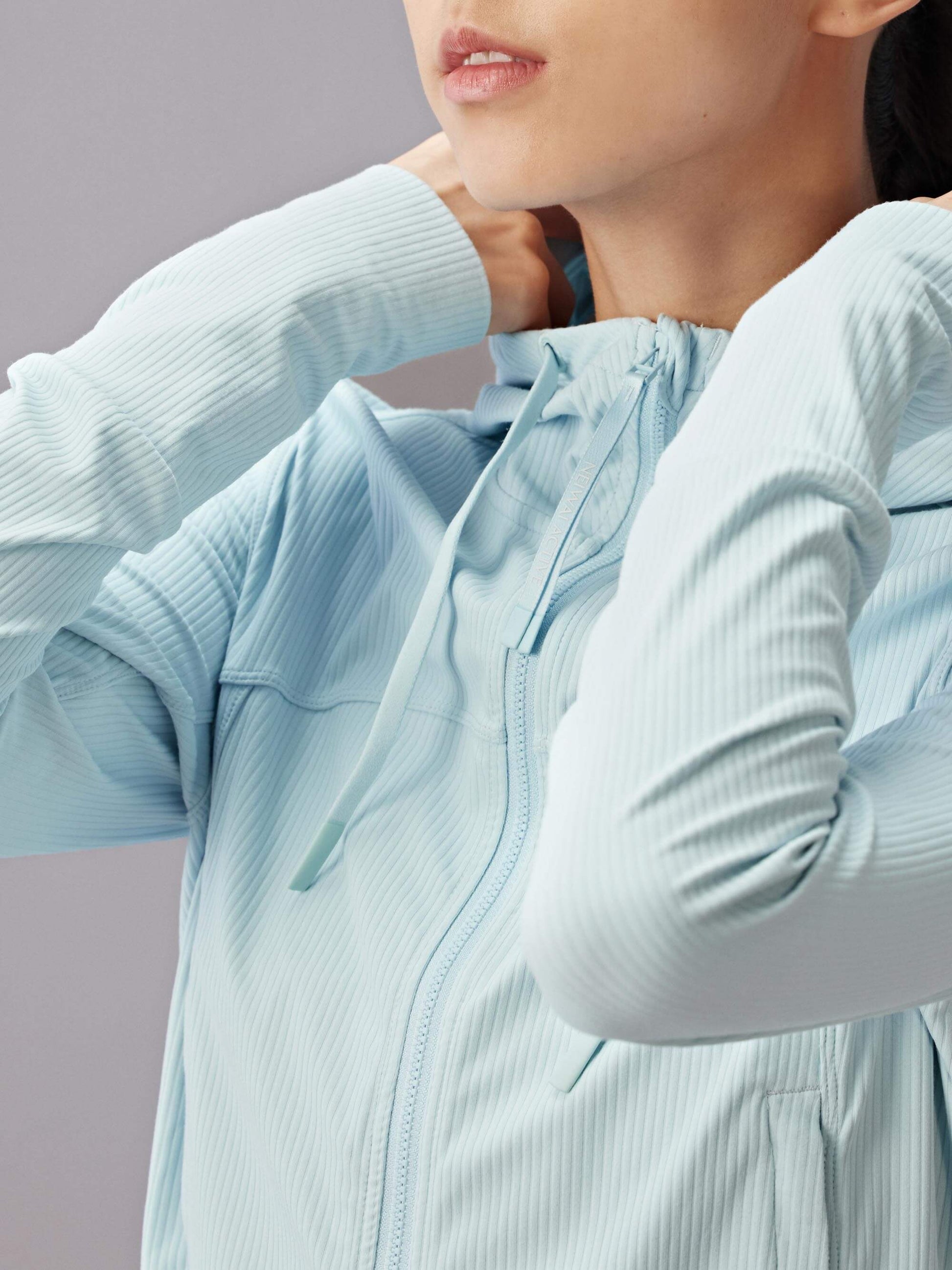 close up of woman in blue zip-up jacket with semi-high collar