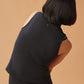 back of woman in black crew neck sleeveless top